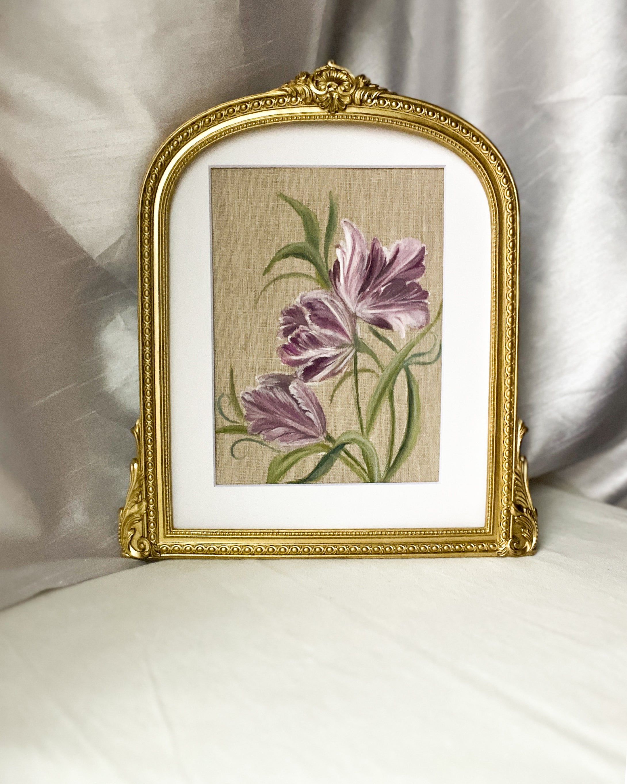 Mystic Bloom by Trisha Patel - framed artwork depicting a purple tulip, placed in a gold-toned, arched wooden frame with ornate detailing.