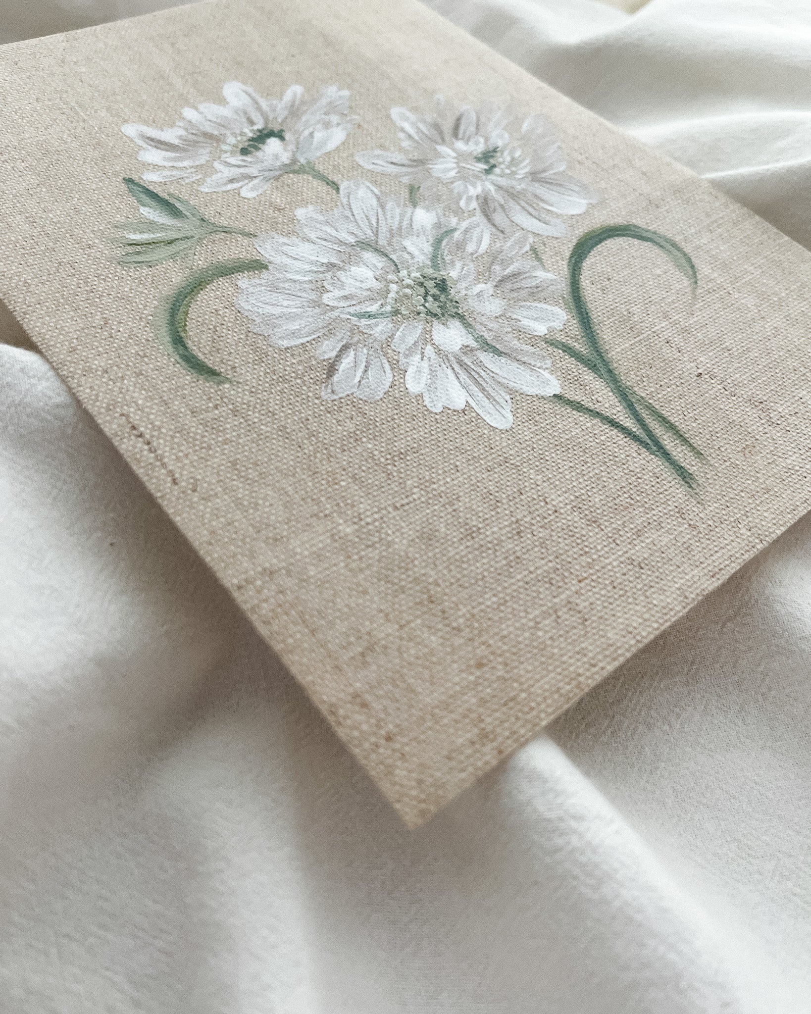 Close-up of 'Reflective Bloom' white scabiosa watercolor painting by Trisha Patel, highlighting delicate white petals and botanical brushwork.