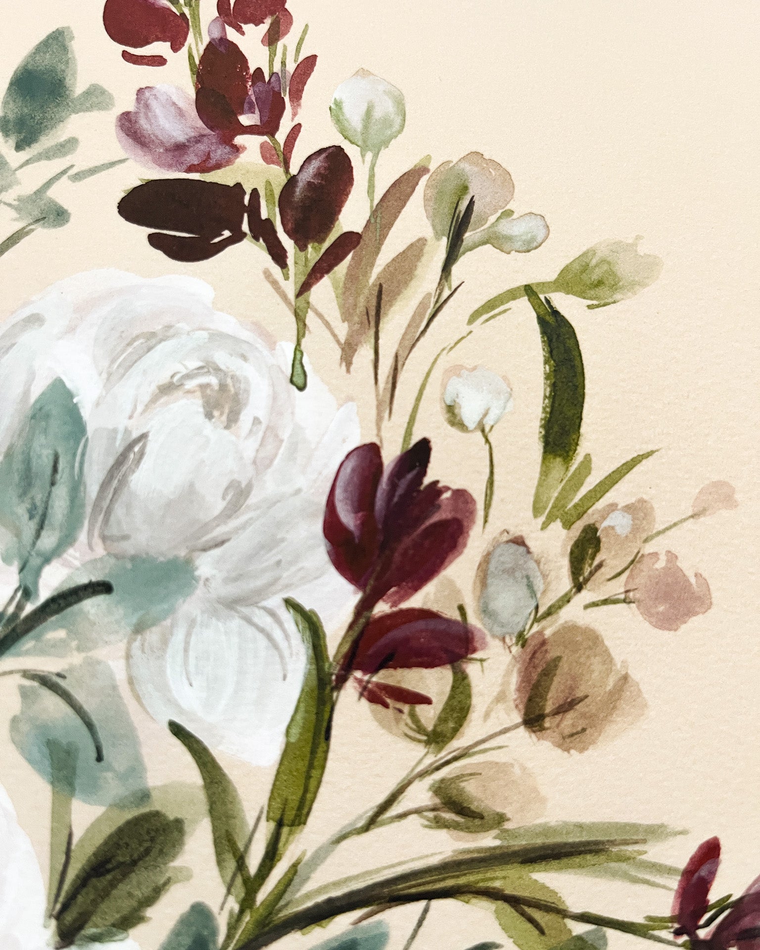 Floral arrangement with white, purple, and green flowers on a beige background