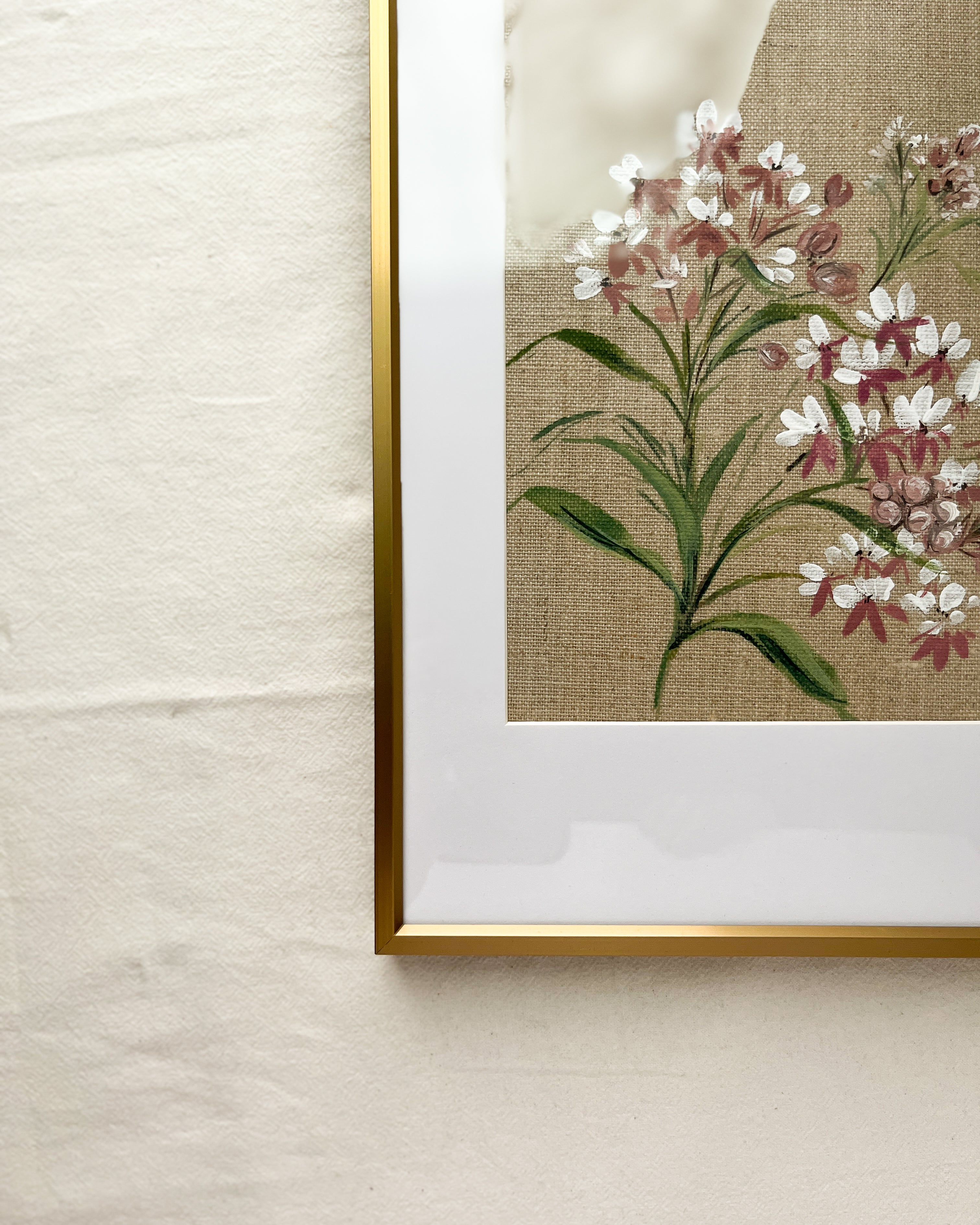 Close-up of sleek gold metal frame with smooth finish and glass on Wings of Change Asclepias watercolor painting by artist Trisha Patel, elegant botanical art display.