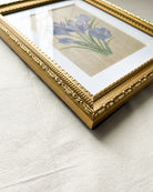 Detailed close-up of embossed floral and beaded pattern on gold-toned wooden frame of Springs Promise crocus watercolor painting by Trisha Patel