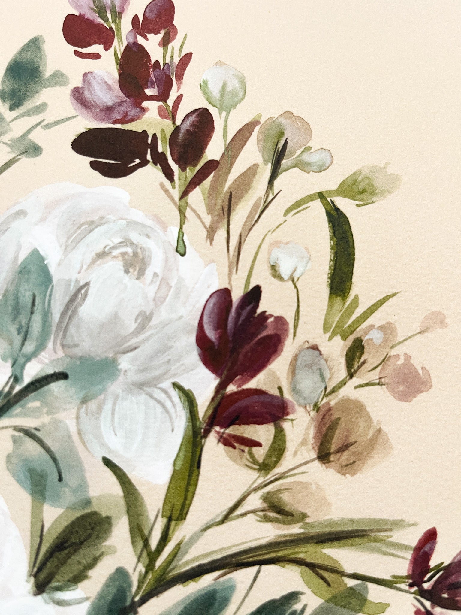 Floral arrangement with white, purple, and green flowers on a beige background